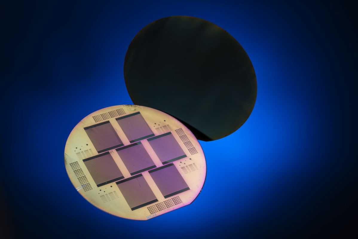 Monocrystalline silicon solar cell with POLO-contacts for both polarities on the solar cell rear side. In the foreground the rear side of seven solar cells processed on one wafer can be seen, in the background the entire front side. Image: ISFH