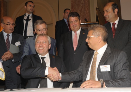 REC's Luc Grare (left) shakes hands with OTMT mergers, acquisitions and business development officer Hatim E. El Gammal, as German minister Sigmar Gabriel (standing, centre), looks on. Image: Manfred Knopp.