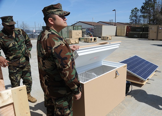 US Military personnel with distributed energy equipment including refrigeration units and solar PV. Image: US DOD / MC2 William S Parker.