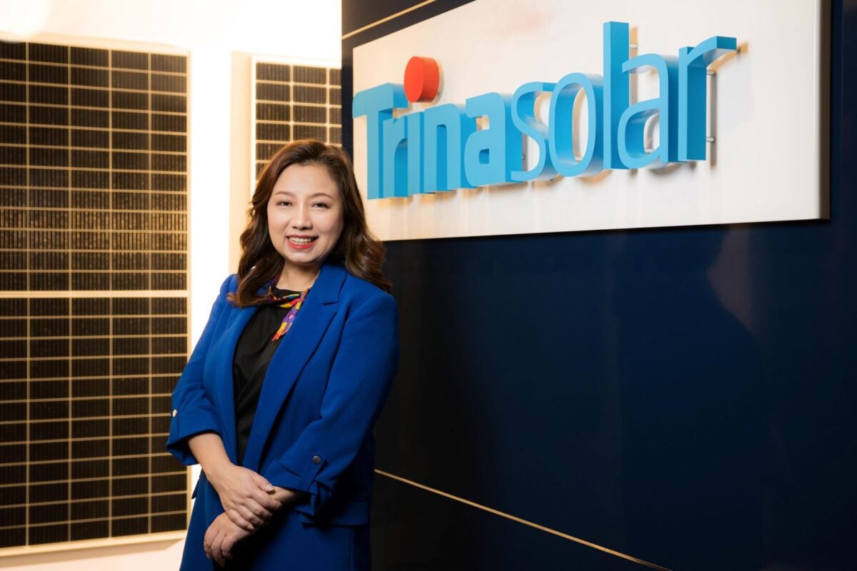 Helena Li, president at Trinasolar in front of the company's logo