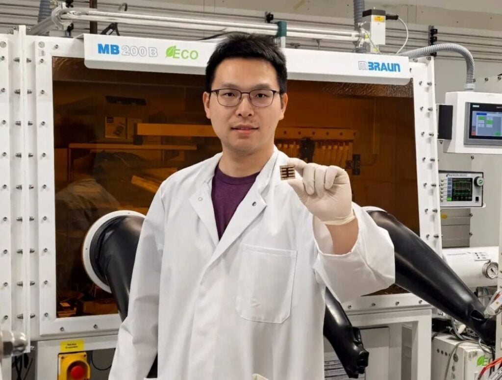 Dr Kun Sun holding a perovskite solar cell.
