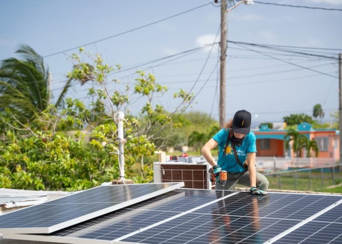 Solar installer on a residential rooftop in Puerto Rico. Image: Barrio Eléctrico.