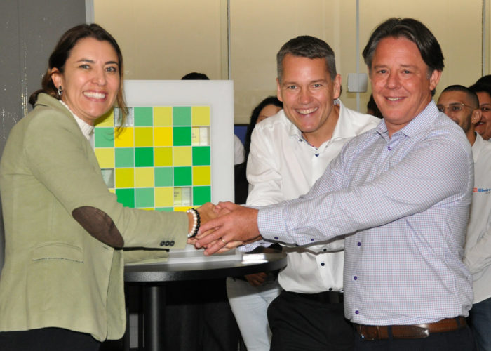 Liciany Ribeiro, Ribeiro Solar CEO (left); Frank Jessel, BayWa r.e. global director of the solar trade division (centre); and Daniel Marino, BayWa r.e. director of solar trade in the Americas shake hands to celebrate the companies' deal. Image: BayWa r.e. and Ribeiro Solar